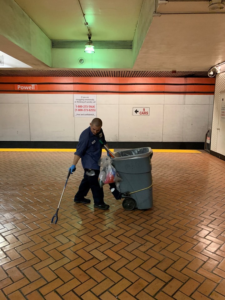 Garrett picking up trash on Powell Station platform
