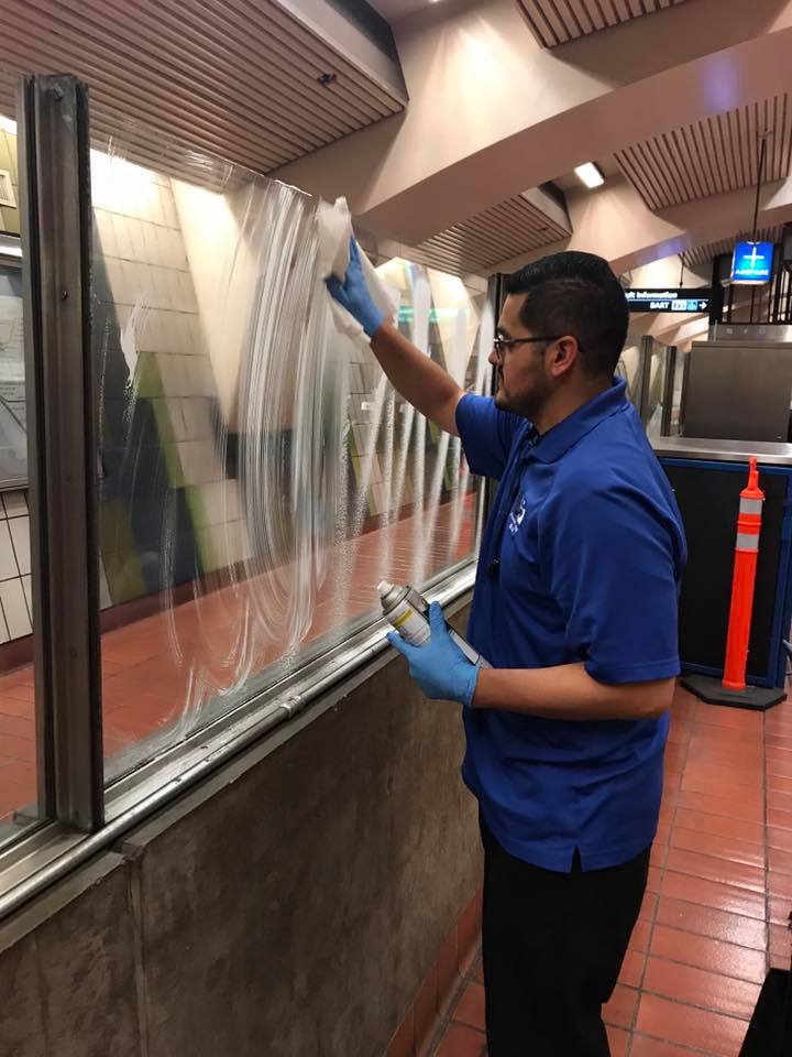 Jorge wiping down window panes at 16th St Mission Station