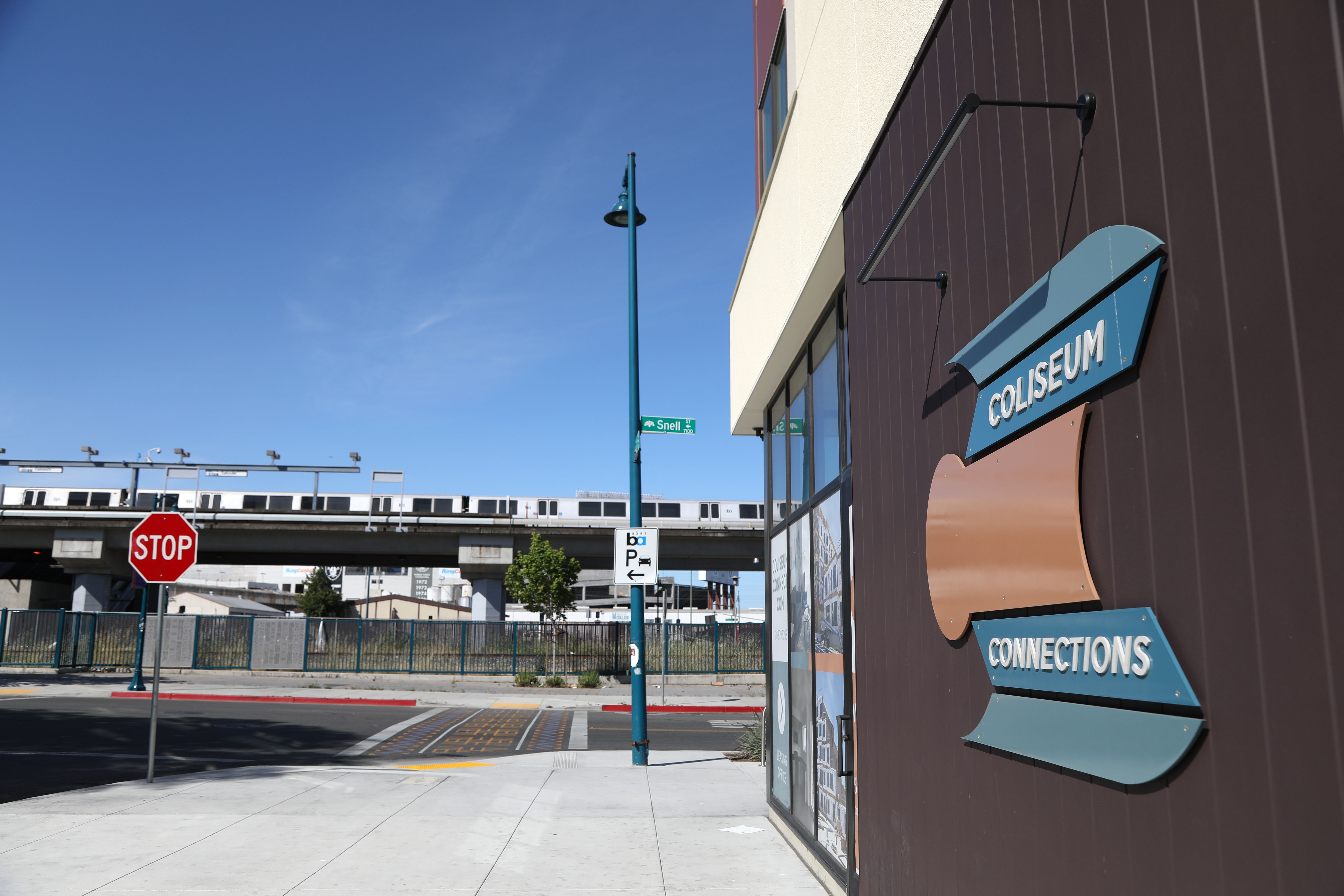 Exterior view of Coliseum Connections building with BART train in the background