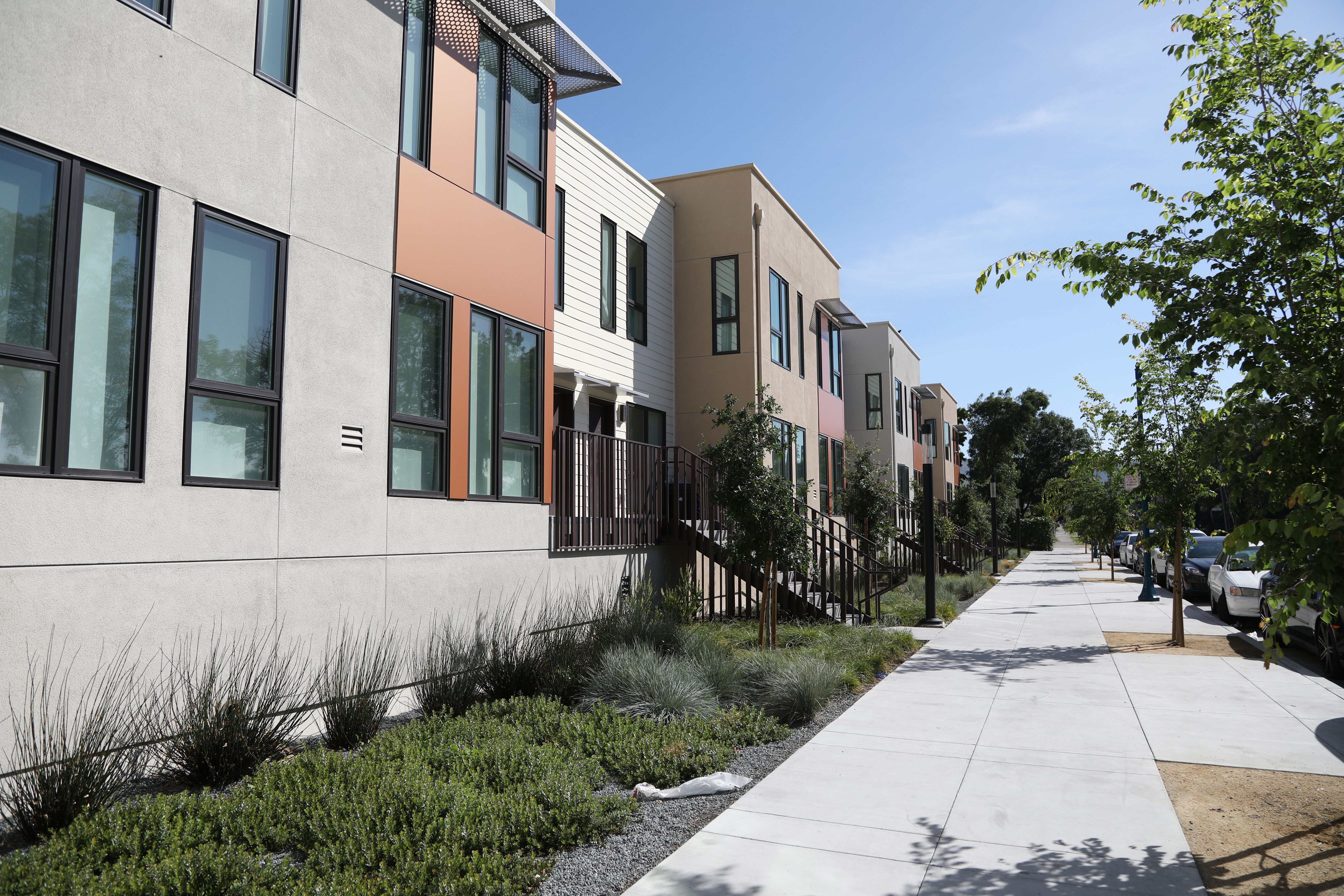 Wide sidewalks and environmentally friendly landscaping surround the apartment units