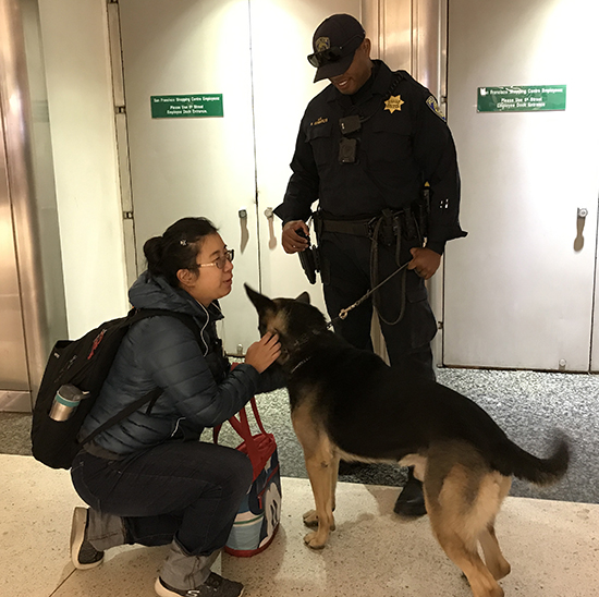 Eileen Lee pets BART PD K-9 Bandi