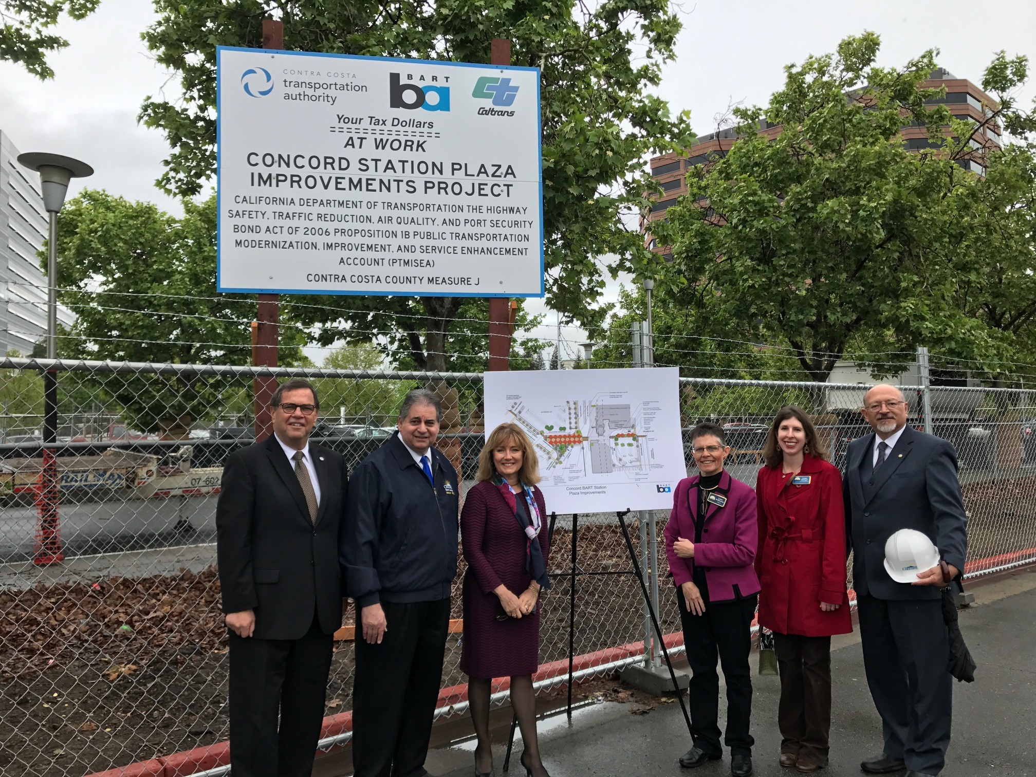 directors and local officials standing in front of construction sign