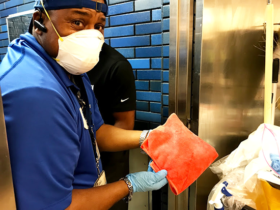 Milton Bradford wears Personal Protective Equipment while cleaning on a field trip to a station.