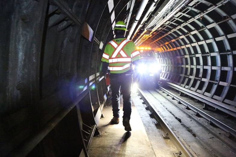 A worker on tunnel walkway going toward truck where staff and supplies are staged