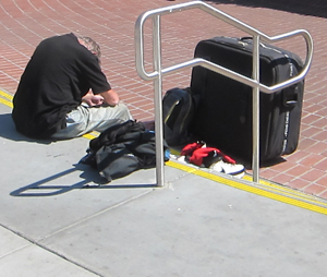 man waits with belongings
