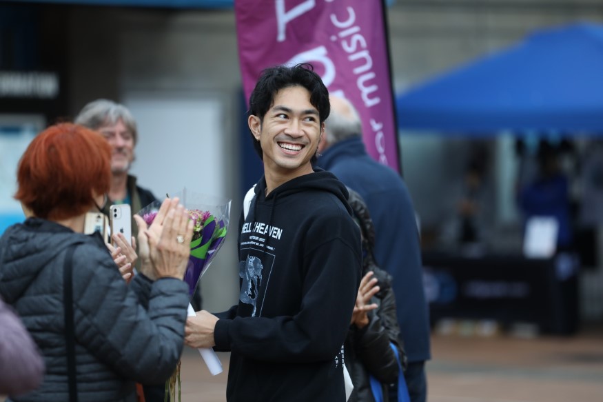 Henry Tran smiles after reading his short story on Oct. 7 at Glen Park Station