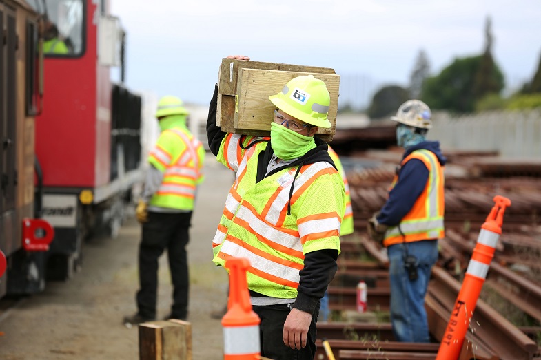 A worker carries wood blocks that are used in positioning a rail grinder. Contractor VSCE Inc. was on site at the Hayward mainte
