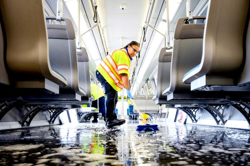 Train car cleaner Alyssa Barnes mops the floor of a BART car with disinfectant soap and steaming hot water during a train car thorough clean.  