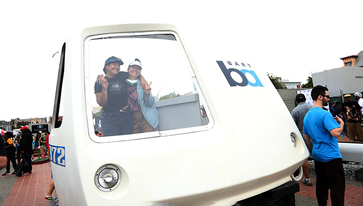 People pose in the nose of a train cab at BART’s 50th Anniversary Celebration and Family Fun Festival on Sept. 10, 2022.