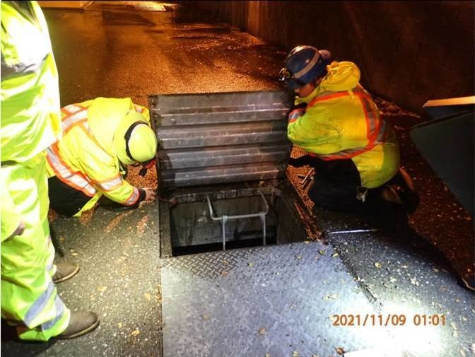 Electrical and micro-duct team surveying and documenting with photos potential cable pathways in manhole