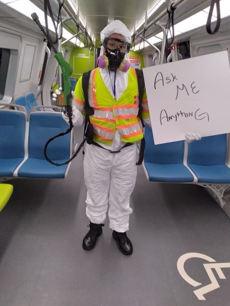 BART Train cleaner holding "Ask Me Anything" sign