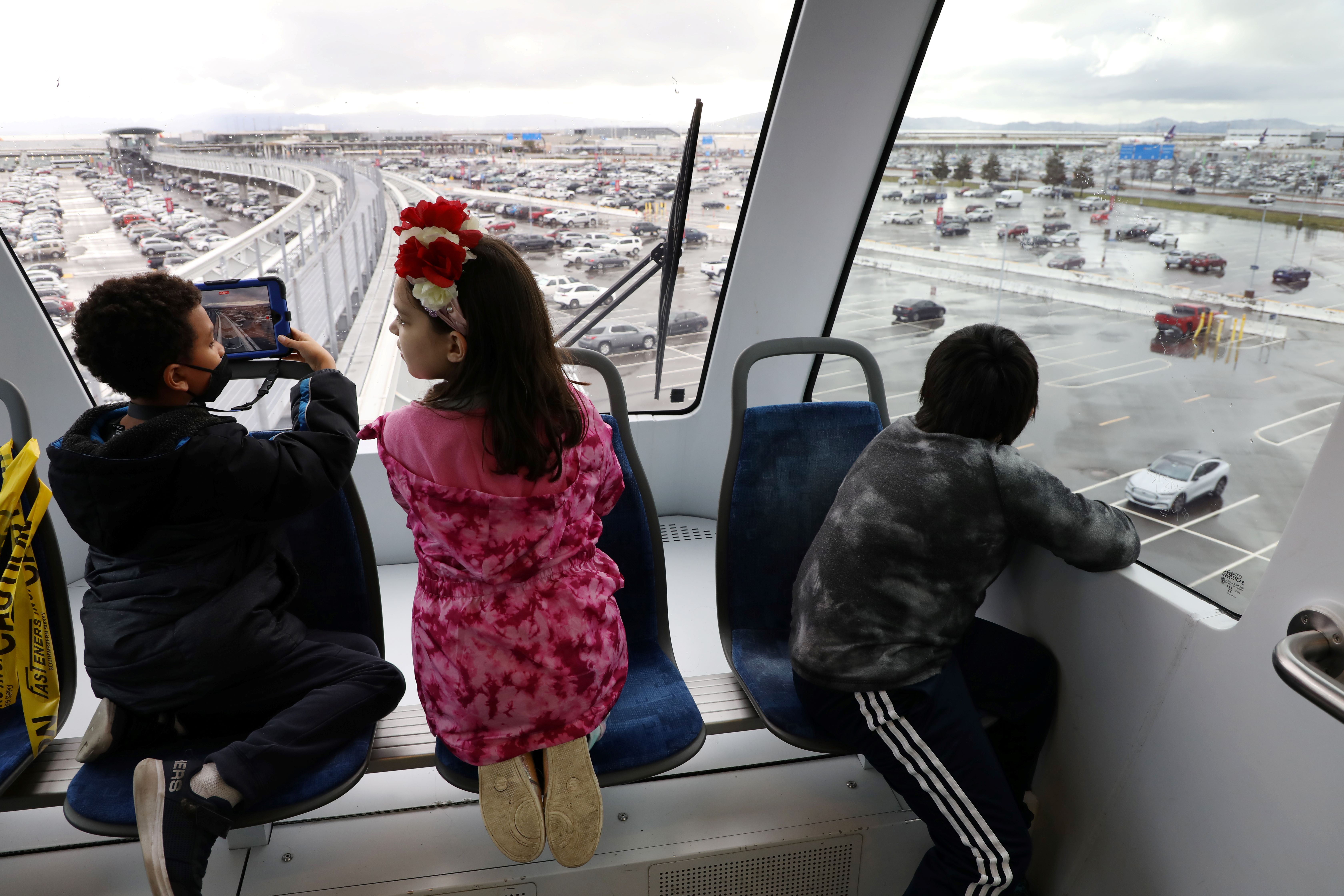 Local children ride the Oakland International Airport Connector from Coliseum Station