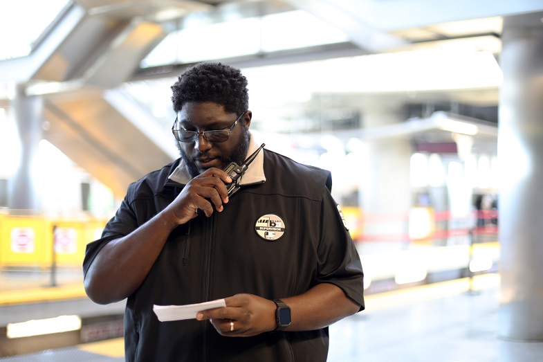 Curtis Zedd Jr. photographed using his radio during a shift at SFO Station on July 9, 2021