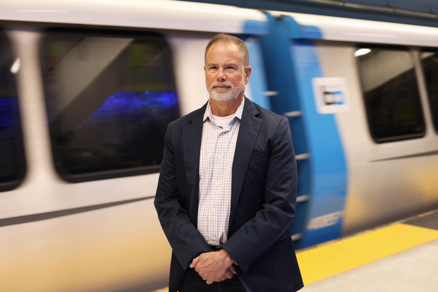 A current photo of James Allison in front of a BART train at 19th St. Station 