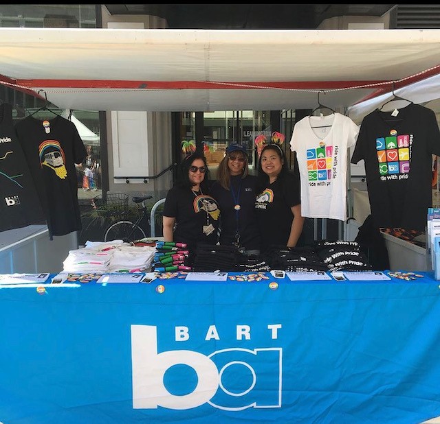 BART Customer Service representative Michelle Pallen-Mendiola poses with staff in front of merchandise booth