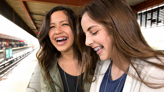 Two girls smiling at BART station