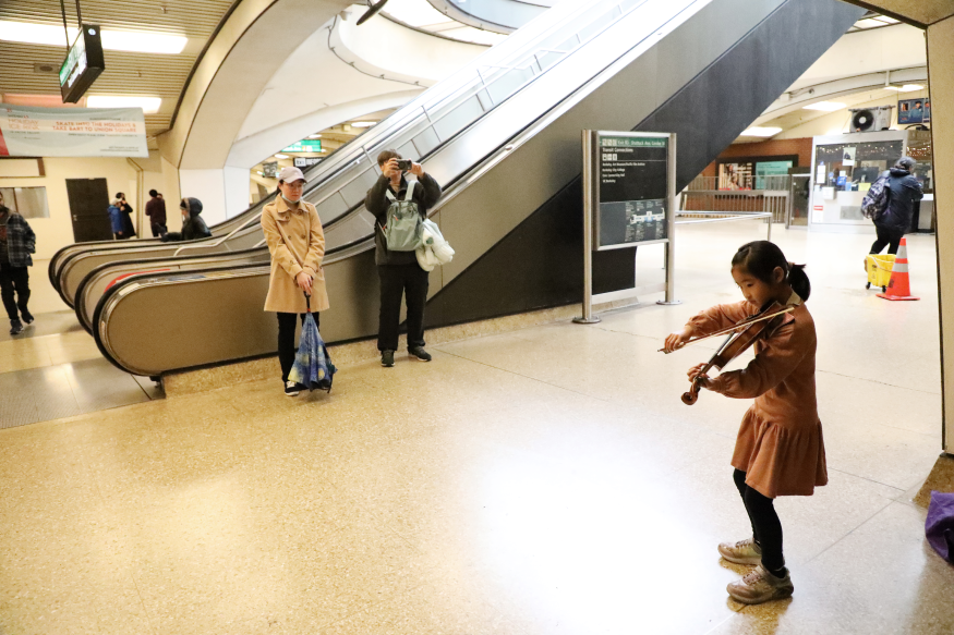 Nana Ng plays violin while performing for Bach in the Subways at Downtown Berkeley Station on March 21, 2023.