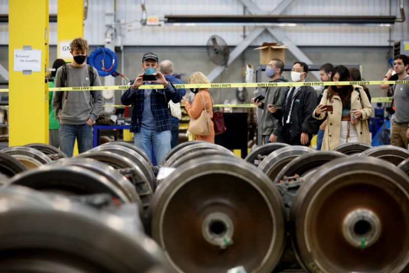 A member of the public takes a photo of car wheels in the Hayward Maintenance Complex during a Board meeting and tour on Oct. 27