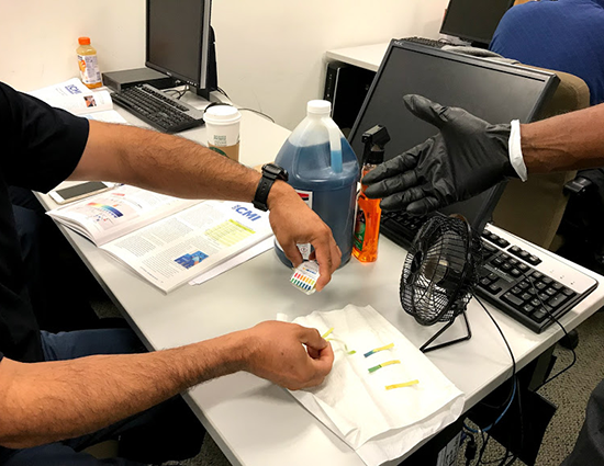 For “The Chemistry of Cleaning,” Ivey assists as a student tests a cleaning solution using litmus strips