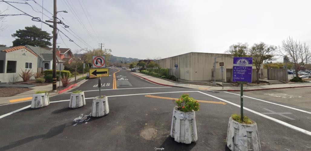 Photo of building corner where artwork will be placed from across the intersection where the Ohlone Greenway connects to the BART station