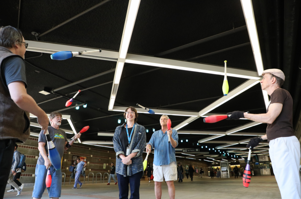 Jugglers toss clubs around a willing member of BART Communications at Castro Valley Station during a Tuesday evening meetup in July.