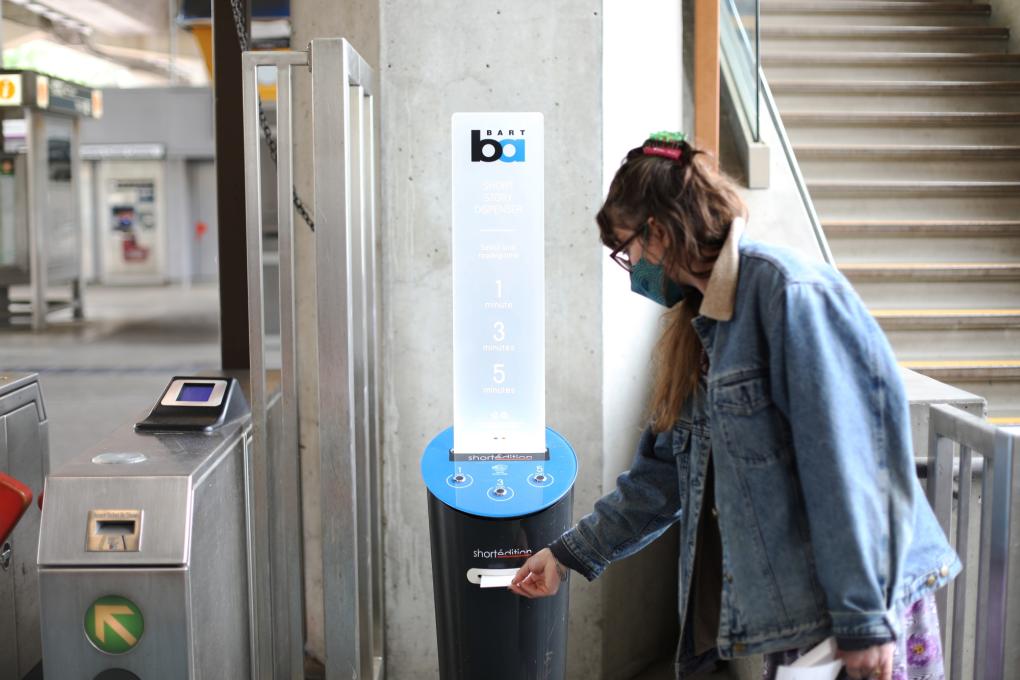 A woman uses a short story dispenser