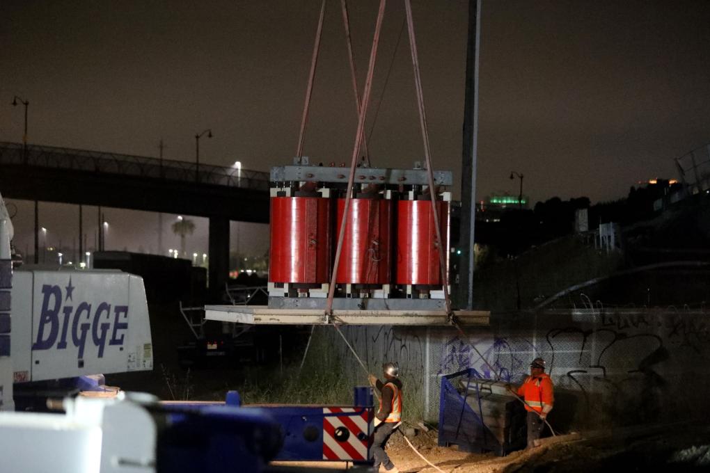 Photo of transforrner equipment being lowered with a crane