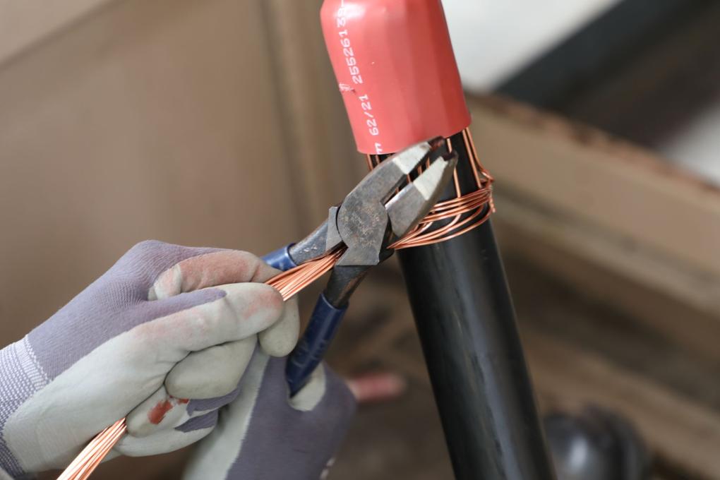 Wire being cut on a piece of transformer equipment