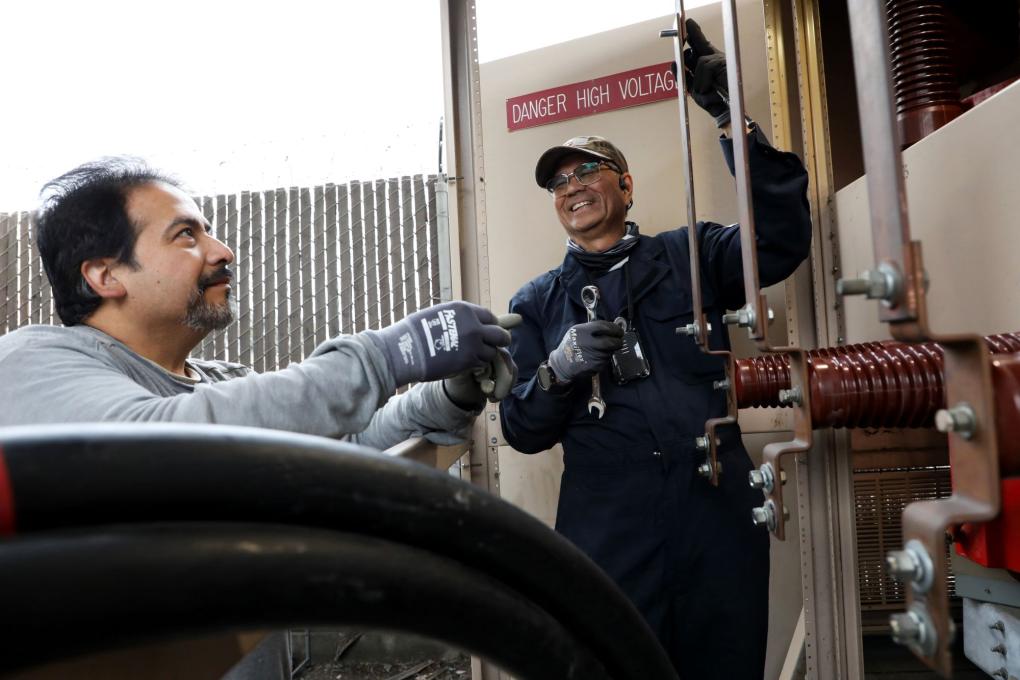 Two people smiling working the transformer