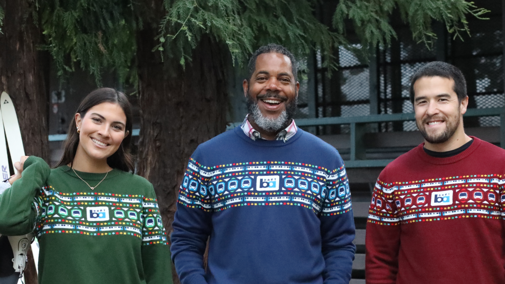 Three people in BART holiday sweaters in green blue and red