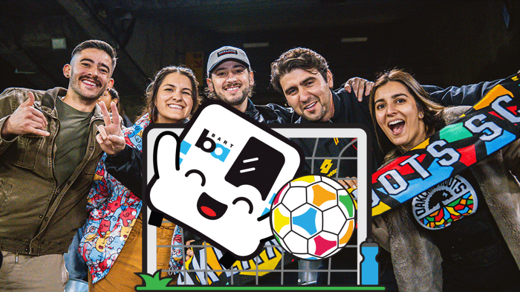 BARTy playing soccer in front of a photo of Roots fans