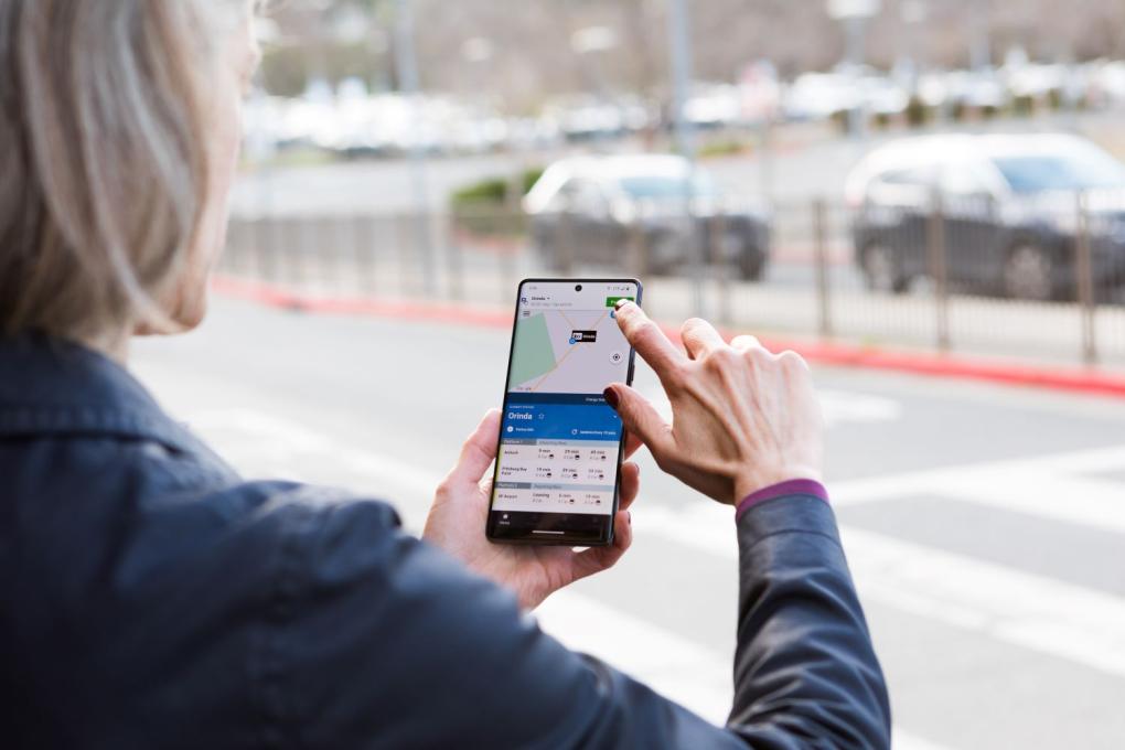 Person using BART app in front of BART parking lot