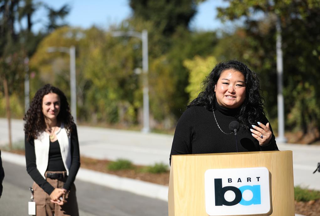 Berkeley Mayor  Adena Ishii speaks at the ribbon cutting at a podium with the BART logo
