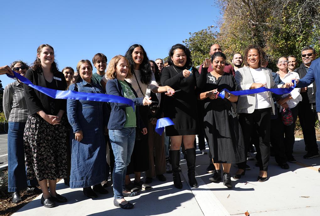 People outside at a ribbon cutting
