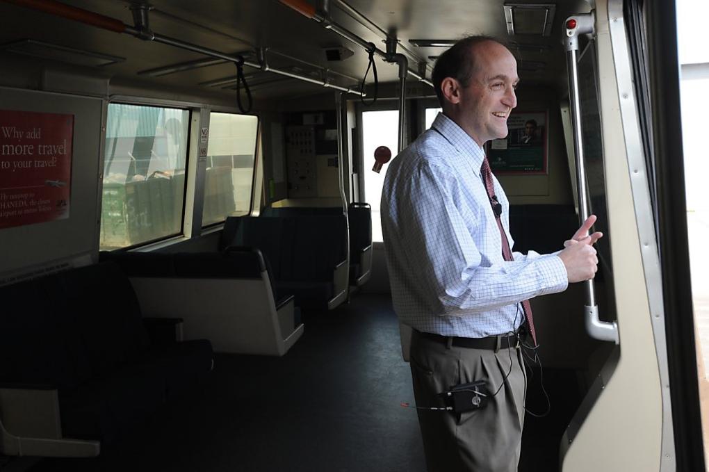 Bob Franklin holding onto a pole inside a legacy BART train