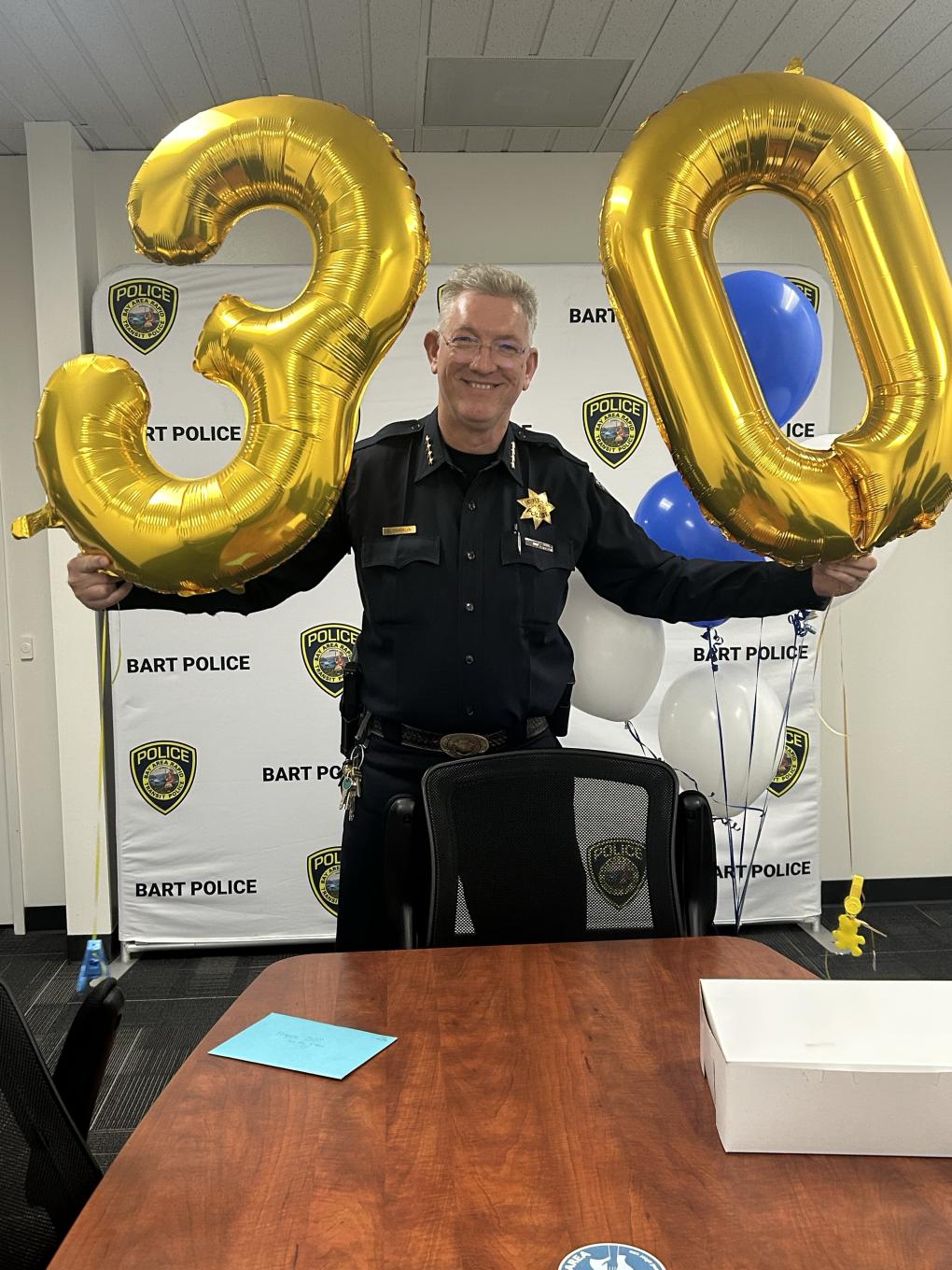 Chief Franklin with balloons in the shape of a 3 and 0