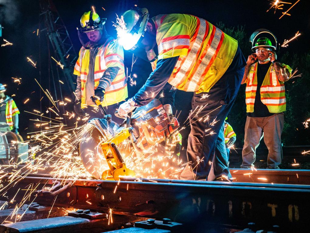 Person cutting rail at night