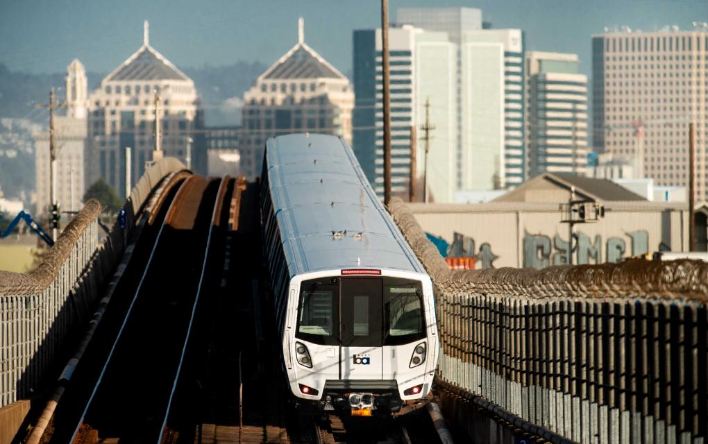 BART train on tracks with Downtown Oakland behind it